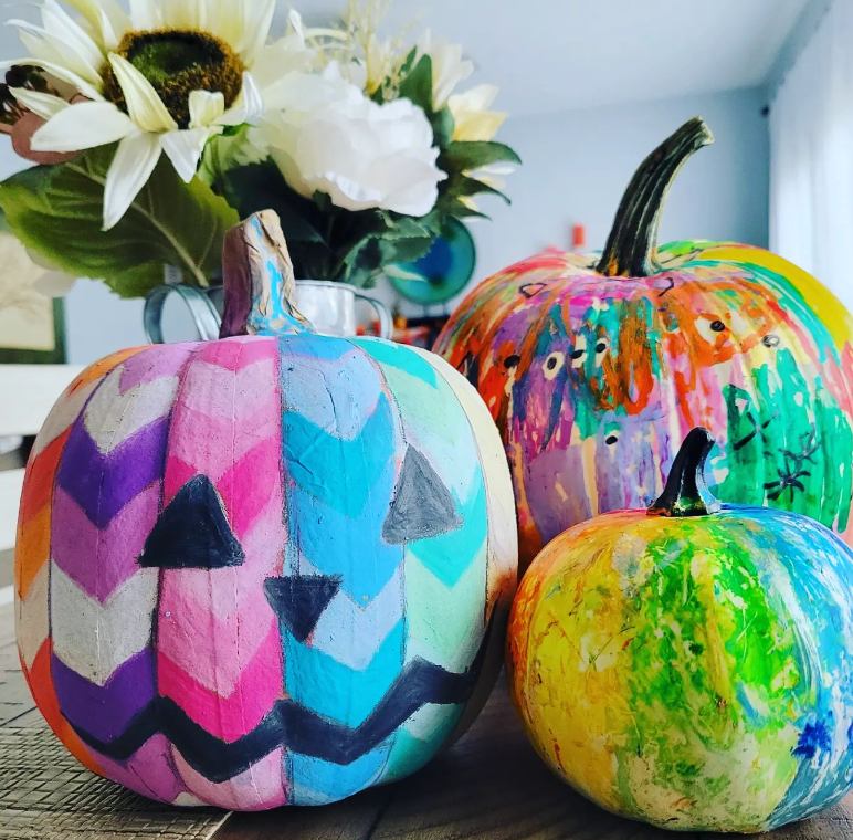 three decorated pumpkins in assorted colors